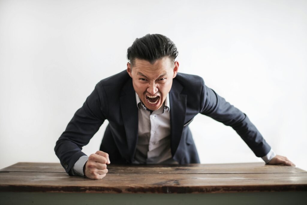 pexels-photo-3760790-3760790 Expressive angry businessman in formal suit looking at camera and screaming with madness while hitting desk with fist