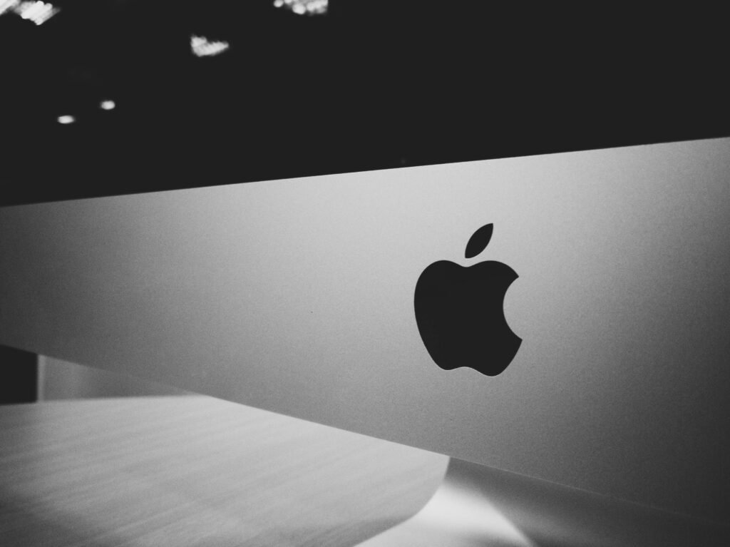 pexels-photo-544295-544295 Close-up of a black and white Apple logo on a desktop screen with a modern minimalist design.
