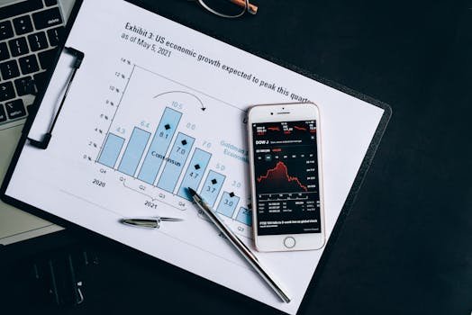 pexels-photo-7887819-7887819 A smartphone displaying stock data rests on a financial report graph.