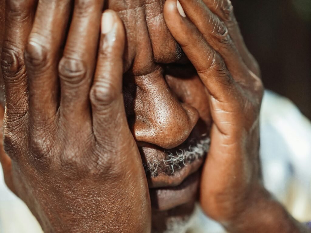 pexels-photo-8173233-8173233 Close-up portrait of an elderly man with hands covering face, showing emotion.